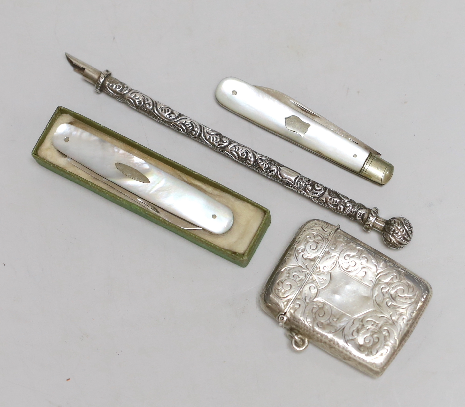 A late Victorian engraved silver vesta case, 53mm, two mother of pearl mounted silver fruit knives and a white metal dip pen.